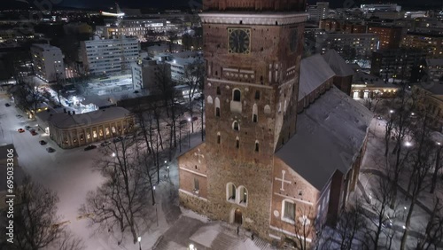 Aerial night view of the medieval Turku Cathedral with big Christmas tree in December, rise in reveal city photo