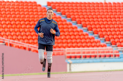 Front view of sport man athlete prosthesis legs is jogging on track in the stadium to practice before copetition in the big event. photo