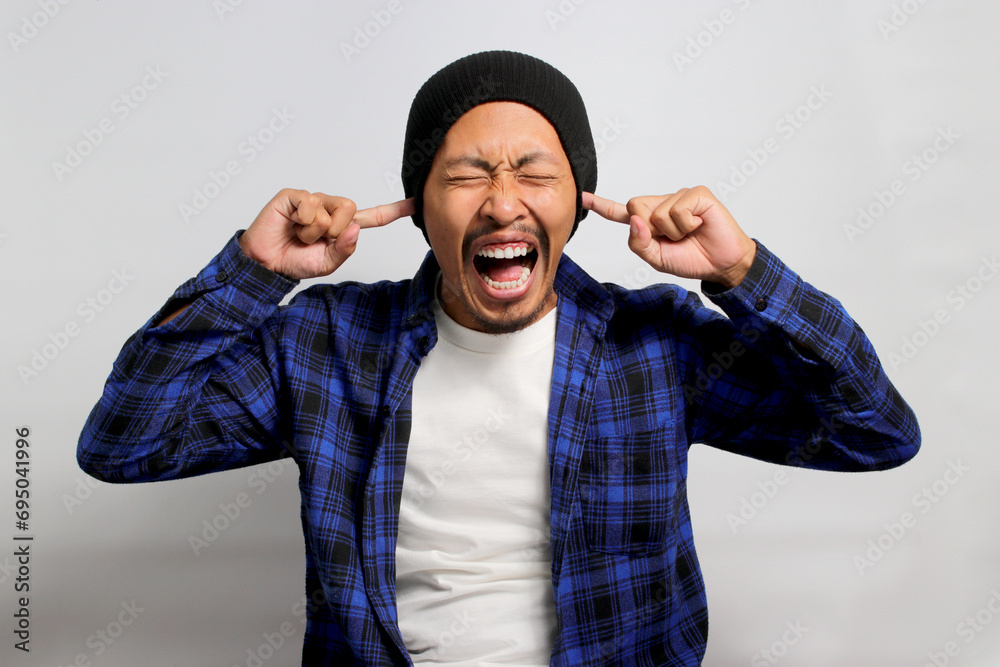 Fotografia do Stock: Angry young Asian man, in a beanie hat and casual ...