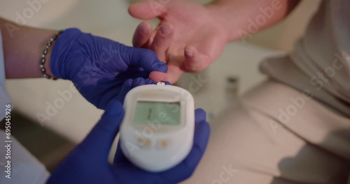 Close up video of doctor using glucometer to check the blood sugar level of patient at the hospital laboratory.