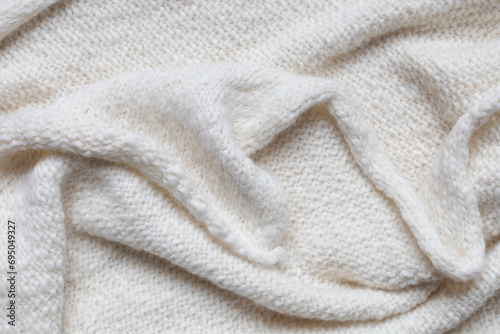 Texture of knitted woolen antique white fabric with folds