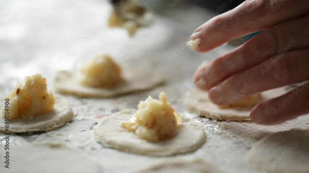A man lays a filling of potatoes in dumplings