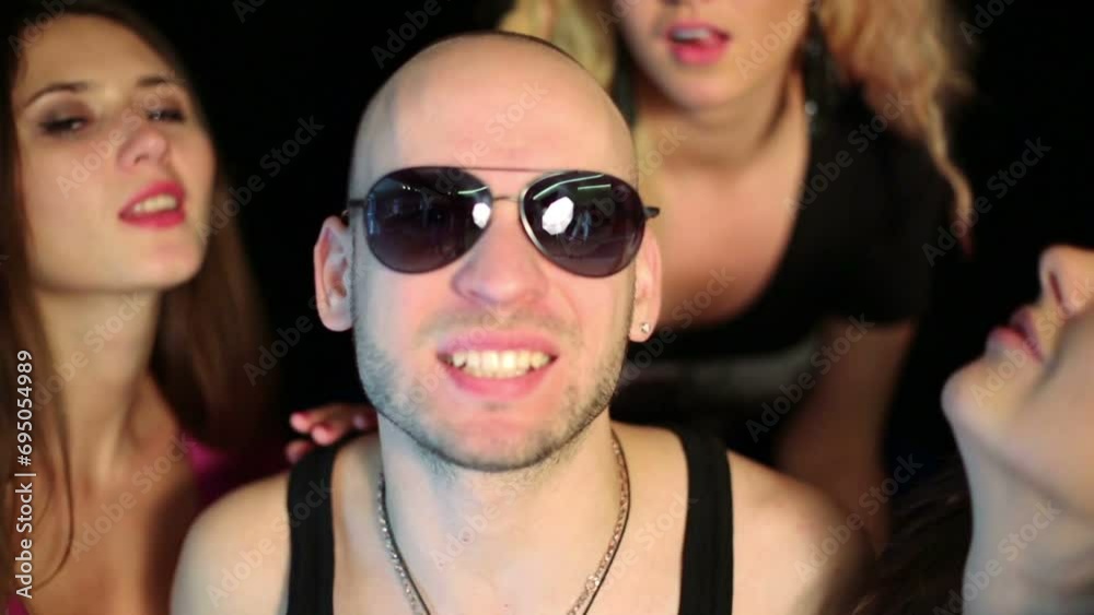 Bald man with sunglasses and three beautiful girls behind him Bald man with sunglasses and three beautiful girls behind him