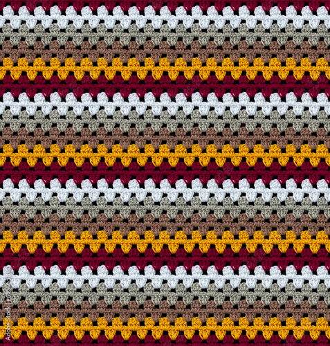 Bright seamless knitted texture. The pattern is crocheted from multi-colored cotton yarn. Zigzag shapes. African motives. 