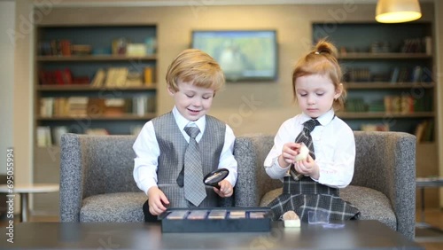 Little boy with magnifying glass and girl in business clothes photo