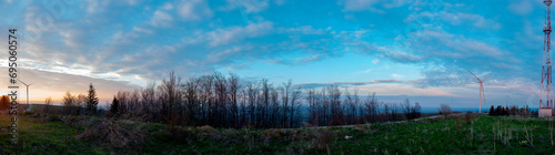 Morning sun on electric windmills  wind wheels with energy support in the west in the foothills. Panorama for banner.