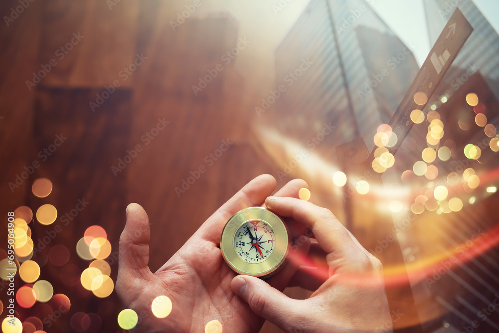 Double exposure businessman with vintage compass in a hand and skyscraper.  concept to make decision or choose direction - obrazy, fototapety, plakaty 