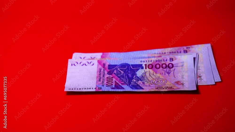 Vidéo Stock Counting 10000 CFA franc notes on red background | Adobe Stock