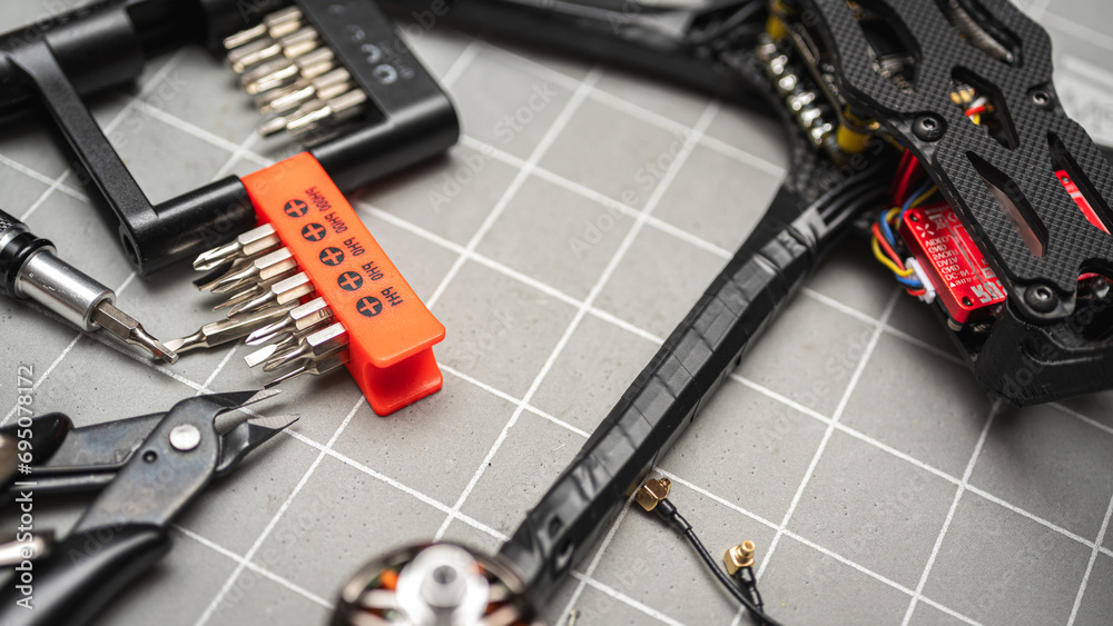 Fototapeta premium Frame, FPV racing drone frame, assembly, soldering, for the armed forces of Ukraine, installed with tools on the desktop, close-up view