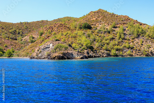 Rocky coast in the resort part of the Mediterranean or Aegean Sea. Background with selective focus and copy space