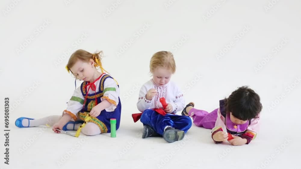 Two boys and girl sit on floor and play with bubbles Two boys and girl sit on floor and play with bubbles