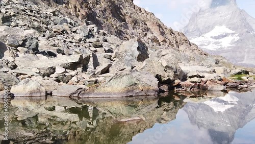 SLOW MOTION:panorama reflection of Mount Matterhorn and Swiss Alps on Riffelsee Lake in Zermatt, Valais, Switzerland. Riffelsee on Riffelseeweg trail, Rotenboden station of Gornergrat Bahn cog railway photo