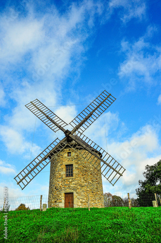 front view, medium distance of, a windmill in Caisdo Pescador, Italy, against blue sky with white clouds