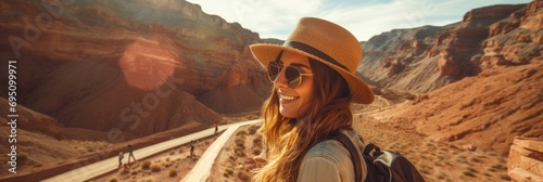 A young girl tourist takes a selfie against the backdrop of the canyon