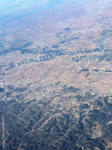 Airplane view. Aerial landscape. Small towns, roads and fields. Scenic top view of earth. High in the sky. Traveling by plane. Amazing beauty of nature. 