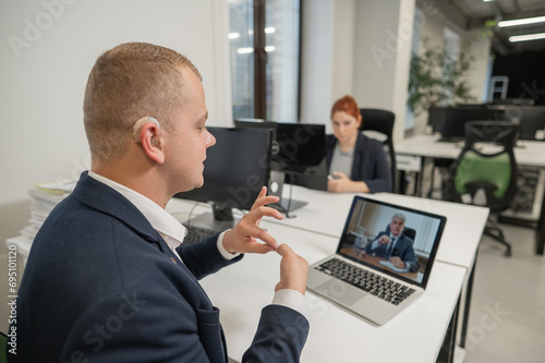 Business partners are talking in sign language to a video call. Two men at a remote business meeting. photo