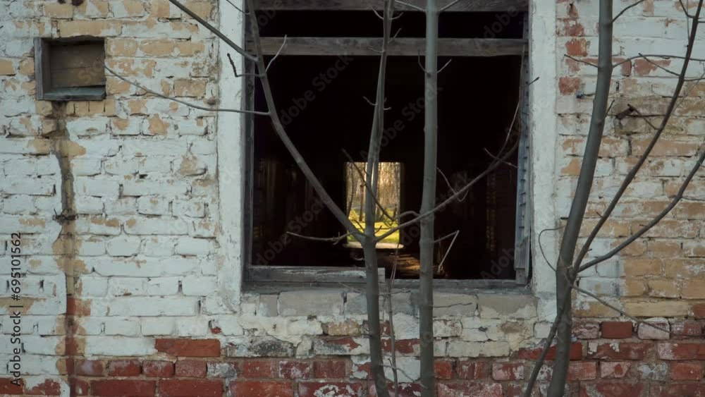 A view, looking through an abandoned brick house spooky empty window to the other sunshine entrance side of this building. A view, looking through an abandoned brick house spooky empty window to the other sunshine entrance side of this building.