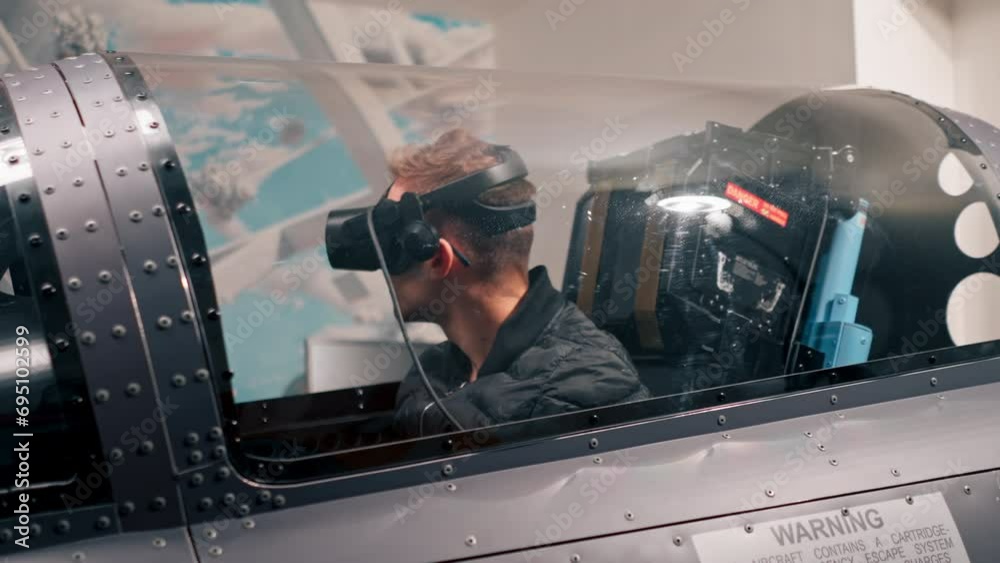 guy sitting in flight simulator of military plane wearing virtual reality glasses during flight entertainment