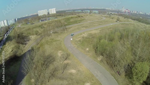 Two cars ride by race track turn at sunny spring day. Aerial view photo