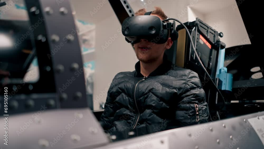 guy sitting in flight simulator of military plane wearing virtual reality glasses during flight entertainment