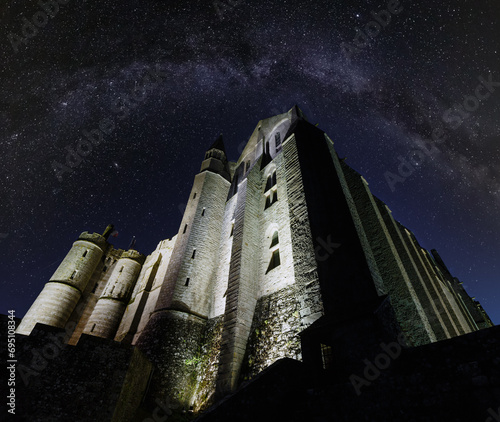 Mont Saint-Michel night view.  Built in the XI-XVI centuries. The main facade of the church  built in the 12th century. Architect  William de Volpiano. Starry sky with Milkyway above. photo