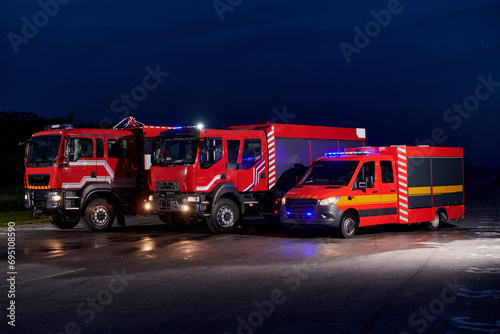 A pair of highly modern and quality fire trucks illuminate the night with their rotating lights, symbolizing the cutting-edge technology and preparedness of the firefighting fleet, ready to respond to
