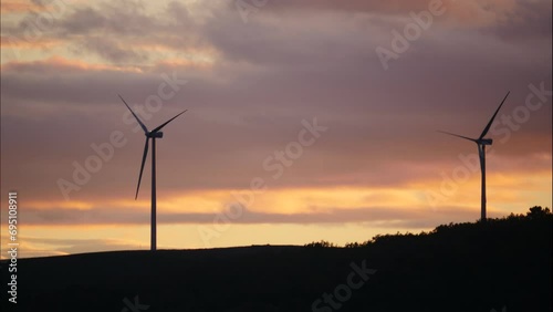 Timelapse of clouds moving over wind turbines on hill. Power generator farm for clean renewable electric energy production, province of Palencia, Castile and Leon community, northern Spain.
 photo