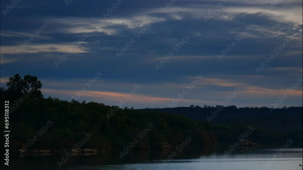 Evening lake landscape. Timelapse of clouds moving over water, light getting darker. Povoa e Meadas Dam in Castelo de Vide, Alentejo Portugal. Evening lake landscape. Timelapse of clouds moving over water, light getting darker. Povoa e Meadas Dam in Castelo de Vide, Alentejo Portugal.
