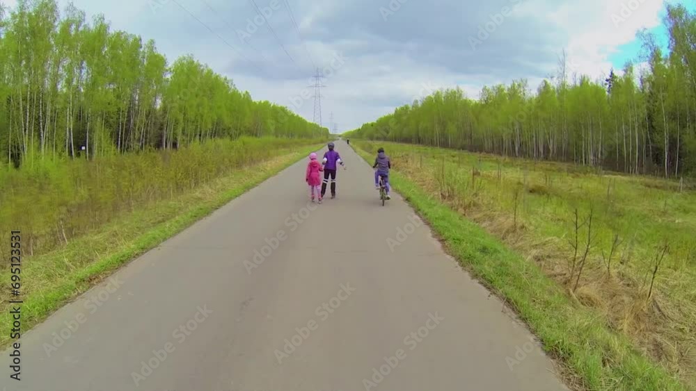 people mother with kids ride on rollerblades and bicycle by road people mother with kids ride on rollerblades and bicycle by road