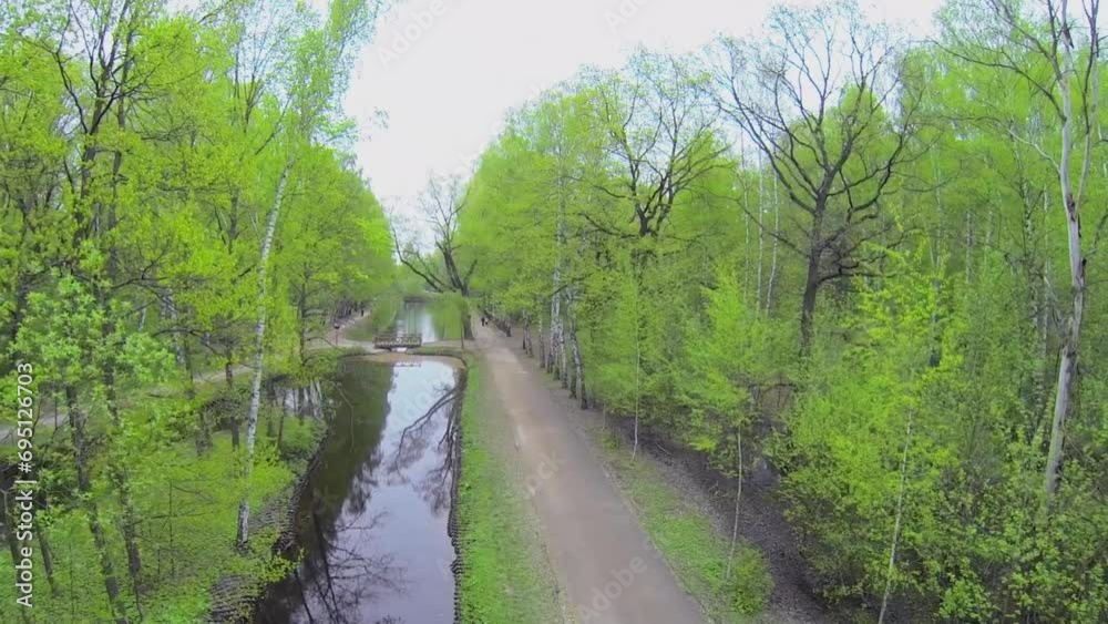 People walk by path near Putyaevsky ponds in park at spring day People walk by path near Putyaevsky ponds in park at spring day