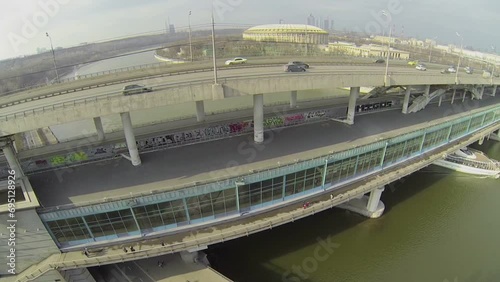 Passengers liner sails by river under metro bridge photo