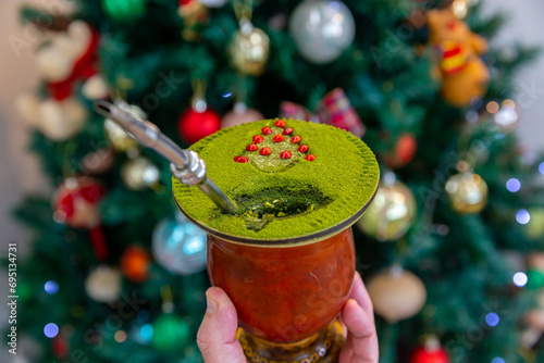 Traditional Brazilian chimarrão prepared with yerba mate (Ilex paraguariensis) decorated with a Christmas theme and with brazilwood seeds photo