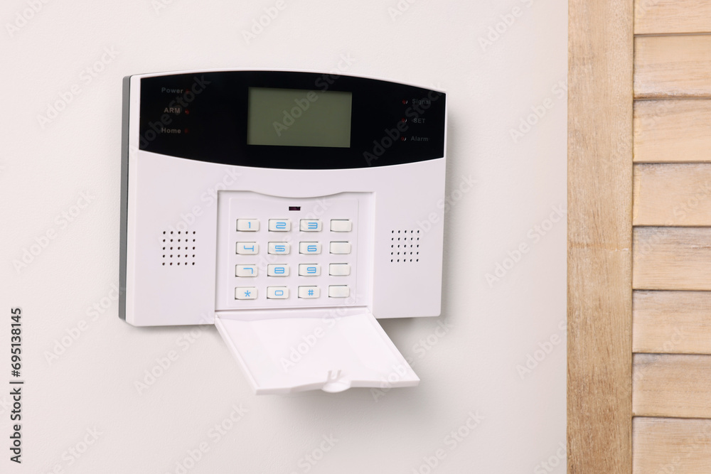 Home security alarm system on white wall indoors Home security alarm system on white wall indoors