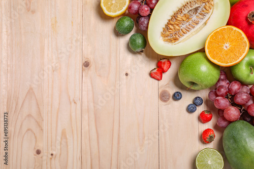 Fototapeta Naklejka Na Ścianę i Meble -  Many different fresh fruits and berries on wooden table, flat lay. Space for text