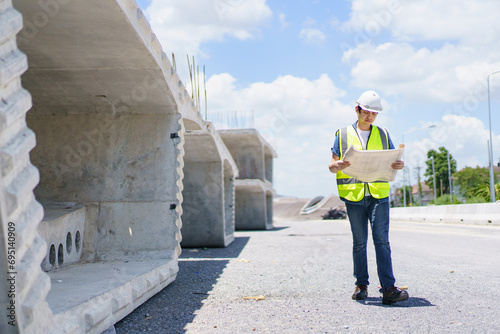 Construction engineer inspecting a segmenting bridge blueprint and construction plan at the site. © DG PhotoStock