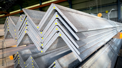 Stacks of angle iron in a factory on shelves in a warehouse Metal profile corners in packs Equal angle steel, angle steel, metal profile angles in packs at the metal products warehouse.