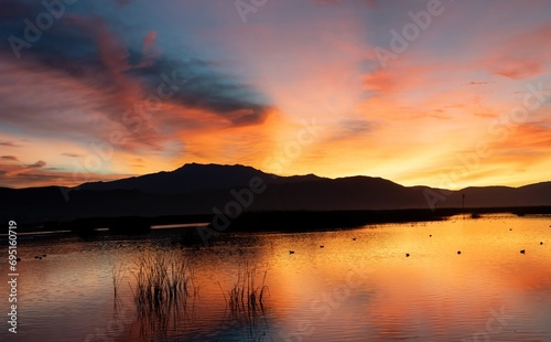 Stunning orange sunrise and its reflection in a lake in San Jacinto, Riverside, California