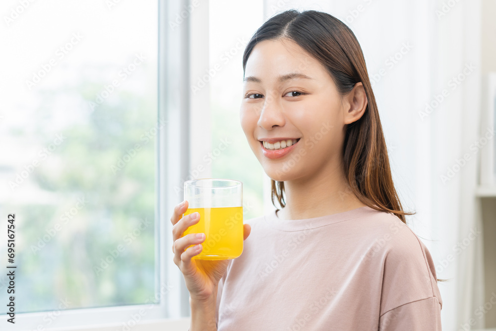 Smile asian young woman, girl hand holding a glass of water after putting or dropping yellow effervescent tablet, painkiller medicine, aspirin for treatment, take vitamin c for hangover, health care. Smile asian young woman, girl hand holding a glass of water after putting or dropping yellow effervescent tablet, painkiller medicine, aspirin for treatment, take vitamin c for hangover, health care.