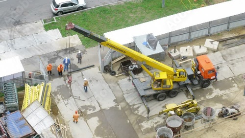 Workers work on a construction site near highway with traffic photo