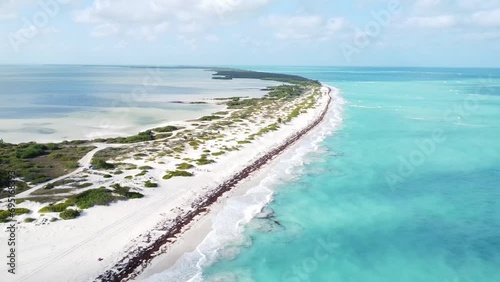 Aerial of Isla Blanca, Mexico, the aerial view unveils a picturesque scene where waves gently crash onto the pristine white sand beach. Long thin peninsula located 20km north of downtown Cancún. photo