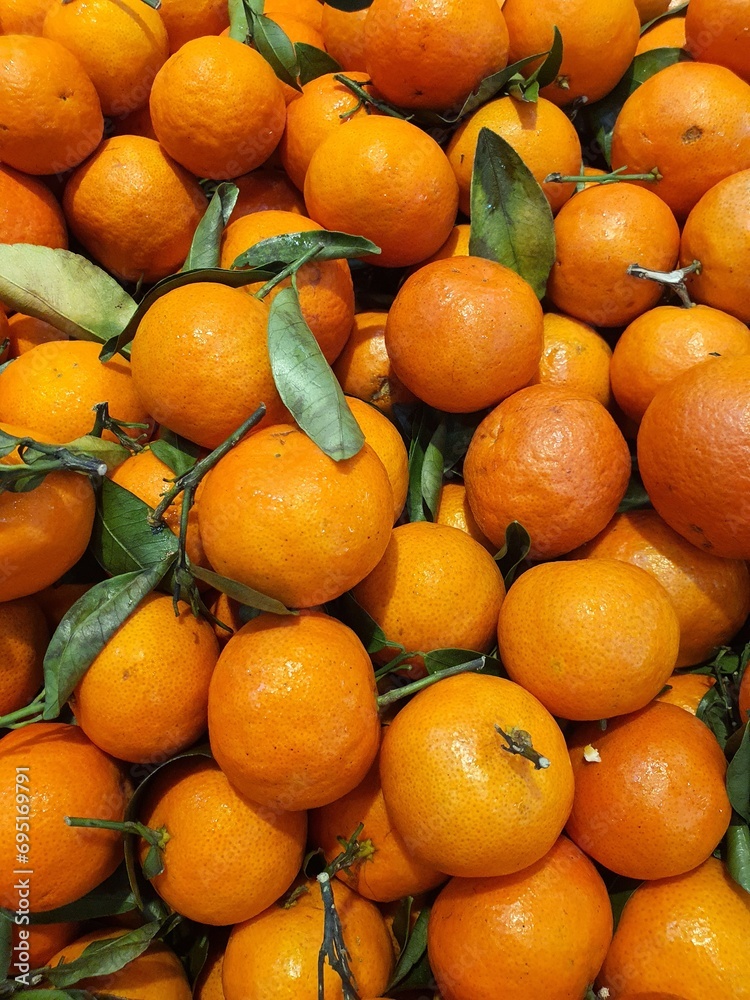 Close up pile of tasty fresh oranges sold at the market as a background.