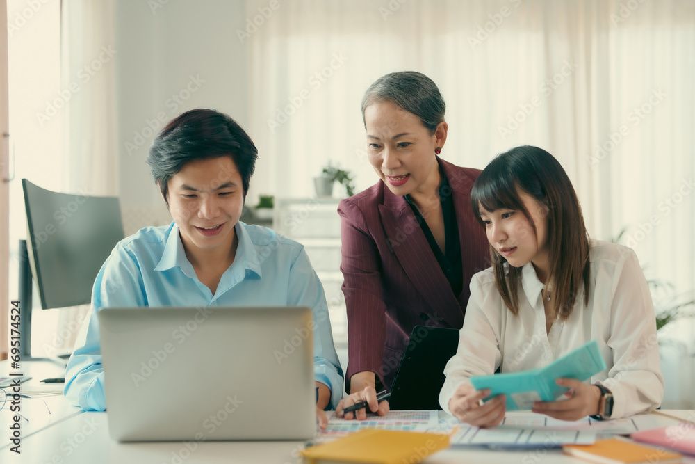 Group of asian designer talking and development ux app on mobile phone during the meeting in office. Group of asian designer talking and development ux app on mobile phone during the meeting in office.