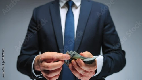 Formally dressed man counting US Dollar bills, close-up. photo