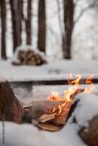 A campfire at a camp site in a winter forest