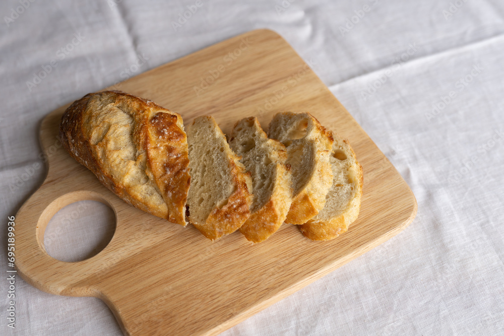 Rustic charm captured in sliced French bread on a wooden board. A simple yet inviting scene, showcasing the artistry of fresh, crusty baguette slices. Rustic charm captured in sliced French bread on a wooden board. A simple yet inviting scene, showcasing the artistry of fresh, crusty baguette slices.