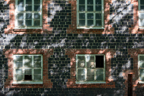 Wall and windows of an old aged brick building