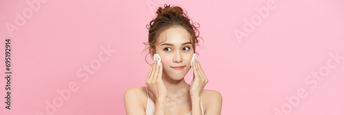 Attractive Asian young woman smile and using cotton with toner cleaning make up so fresh and clean photo
