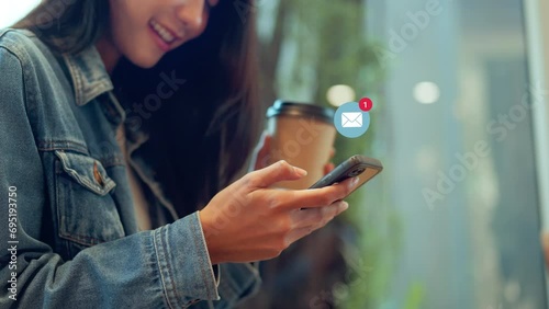 Woman hands using smartphone with 1 new email alert sign icon pop up, Female using phone for check email for work or sending text SMS short message while holding coffee cup at cafe. photo