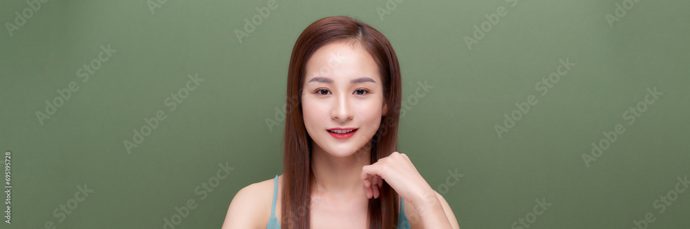 Portrait of young woman with perfect skin clean on green banner background Portrait of young woman with perfect skin clean on green banner background