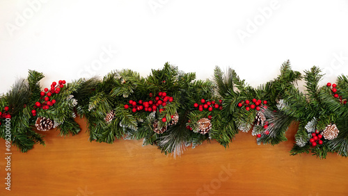 Empty wooden wall in the background of decorated Christmas tree branches in white room with copy space on top. Ready for product montage. © surasak